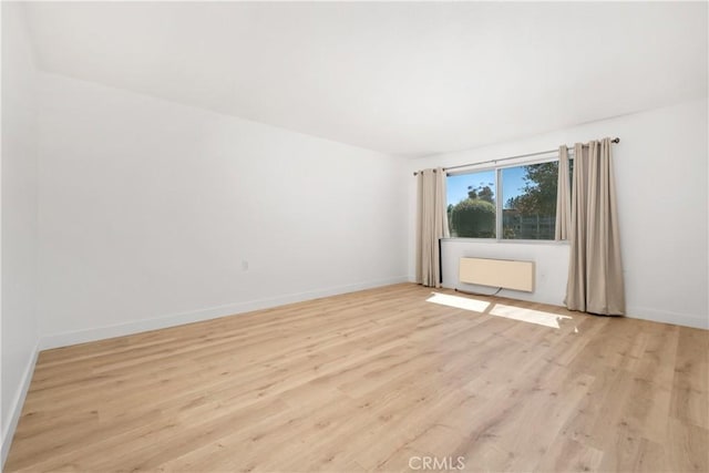 spare room with light wood finished floors and baseboards