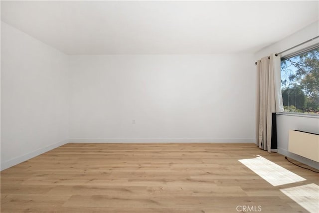 empty room featuring baseboards and light wood-type flooring