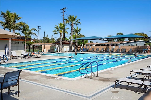 community pool with fence and a patio area