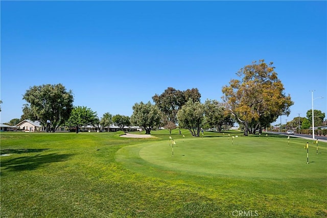 surrounding community with golf course view and a lawn