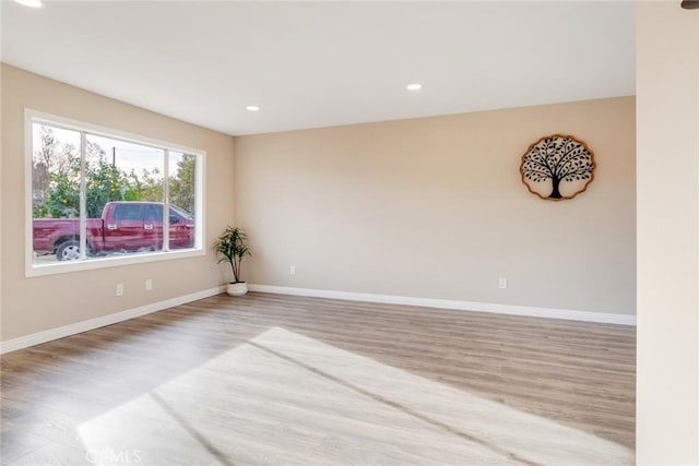 empty room featuring baseboards, wood finished floors, and recessed lighting