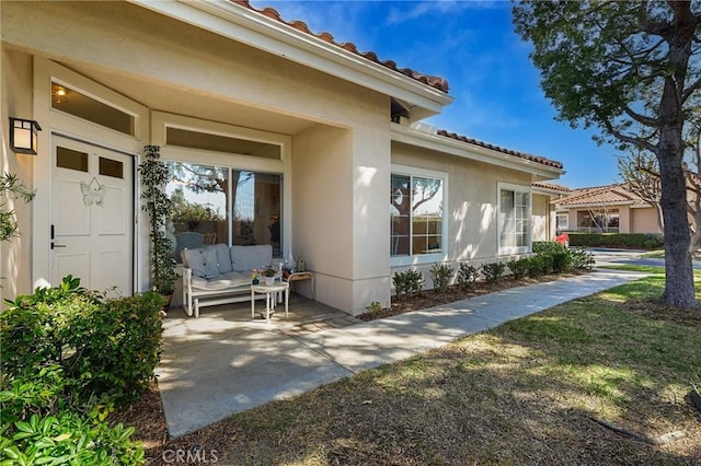 doorway to property with a tiled roof and stucco siding