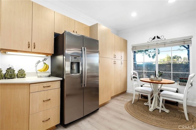 kitchen featuring light countertops, light brown cabinetry, ornamental molding, light wood-type flooring, and stainless steel fridge with ice dispenser