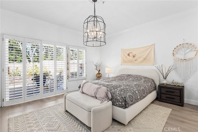 bedroom with crown molding, wood finished floors, baseboards, access to outside, and an inviting chandelier