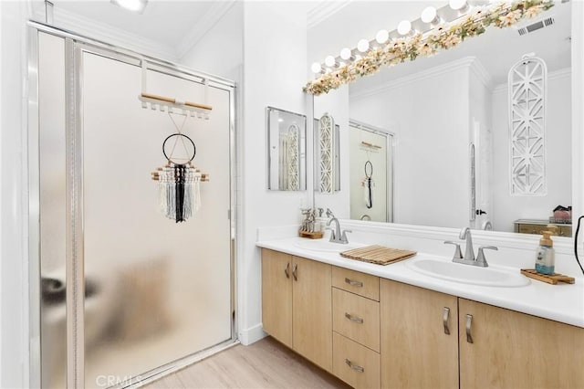 full bath featuring a shower stall, a sink, visible vents, and crown molding