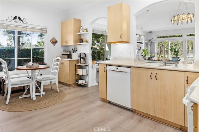 kitchen with dishwasher, light brown cabinetry, a sink, and light countertops