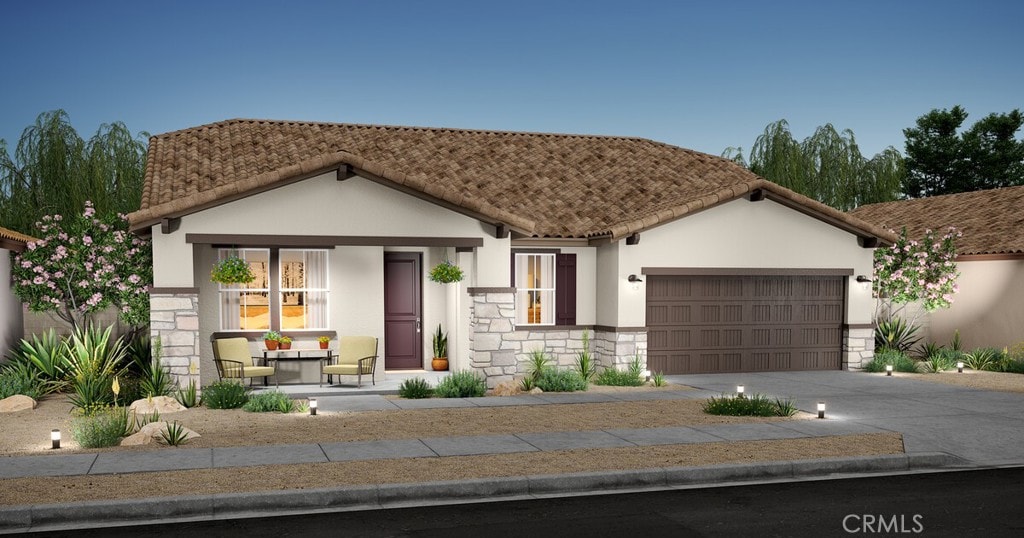 view of front facade with an attached garage, a tile roof, stone siding, driveway, and stucco siding