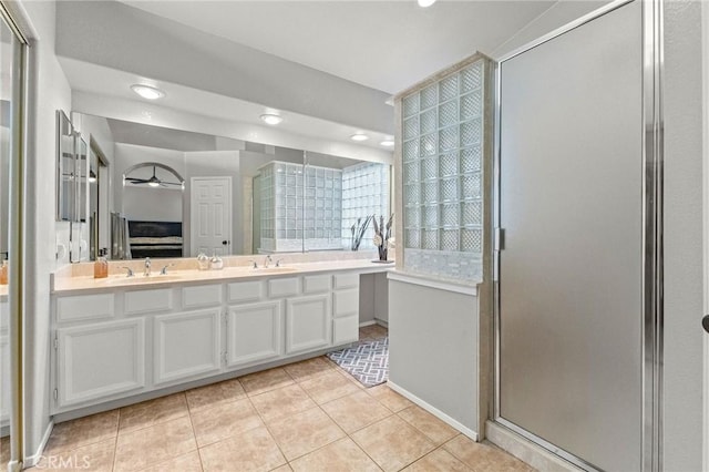 ensuite bathroom with a sink, connected bathroom, a shower stall, and tile patterned flooring