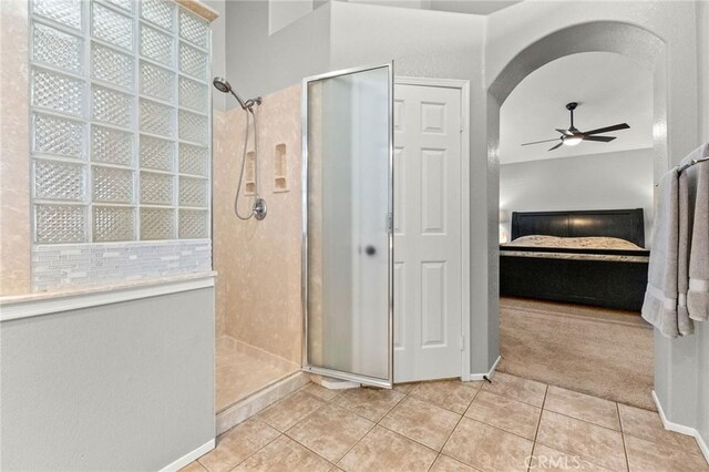 ensuite bathroom with tile patterned flooring, ensuite bathroom, a ceiling fan, and a tile shower