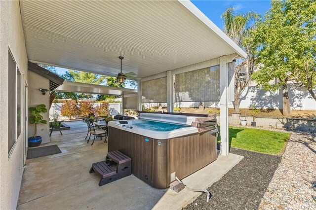 view of patio / terrace featuring a fenced backyard, a ceiling fan, and a hot tub