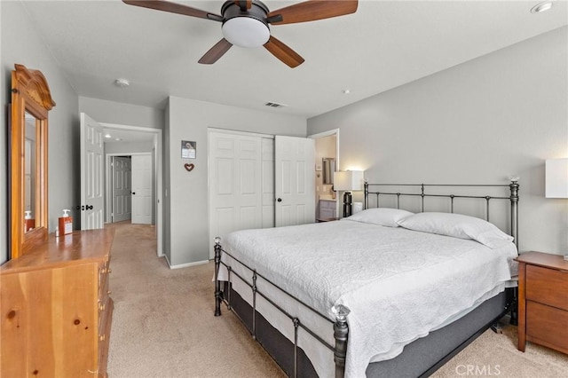 bedroom with visible vents, baseboards, ceiling fan, light carpet, and a closet