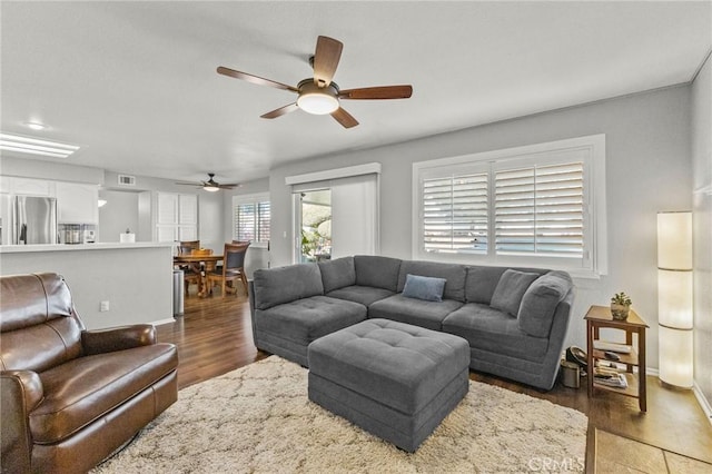 living area featuring ceiling fan, wood finished floors, visible vents, and baseboards