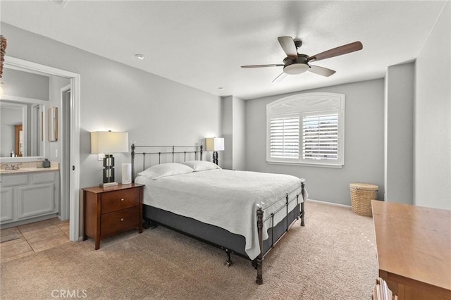 bedroom featuring a sink, connected bathroom, light carpet, and a ceiling fan