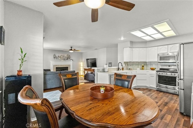 dining space with dark wood-type flooring and a tile fireplace