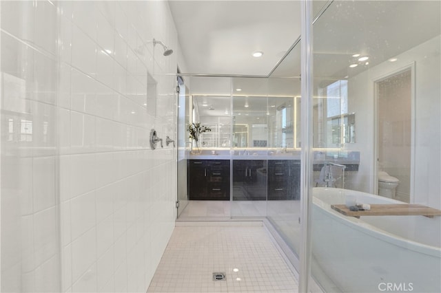 bathroom with toilet, tile patterned flooring, a washtub, walk in shower, and vanity