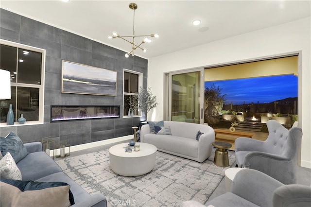 living area featuring a tile fireplace, recessed lighting, and an inviting chandelier