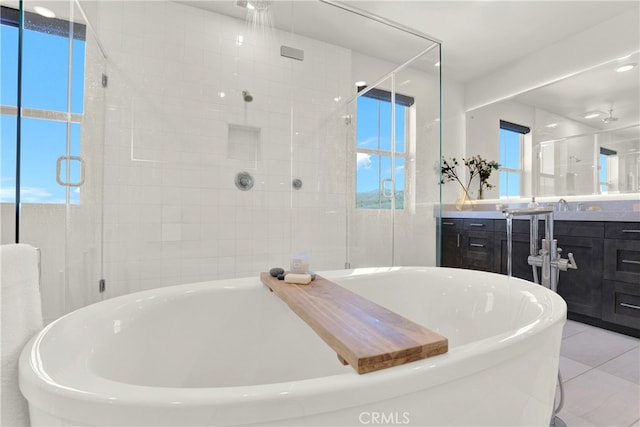 full bath with a stall shower, tile patterned flooring, a soaking tub, and vanity