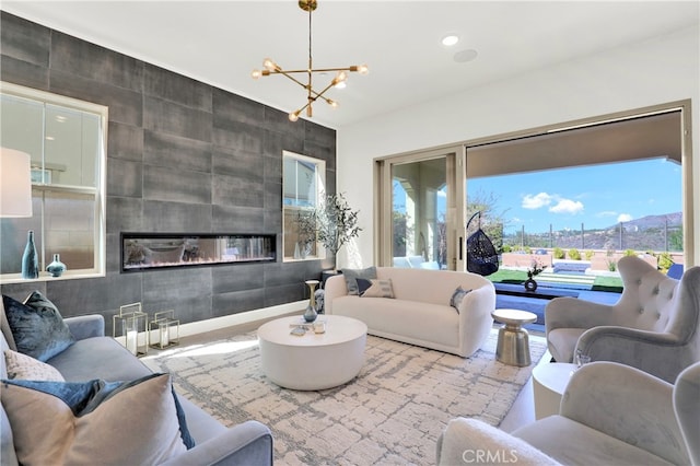 living area with a healthy amount of sunlight, a chandelier, a tiled fireplace, and recessed lighting