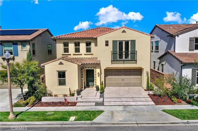 mediterranean / spanish home featuring a tile roof, stucco siding, concrete driveway, an attached garage, and a balcony