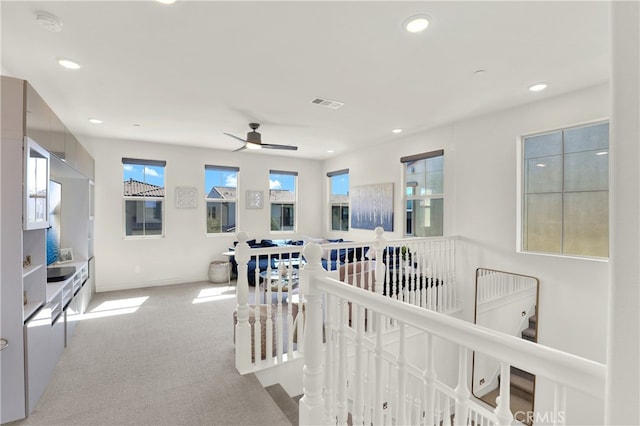 corridor with recessed lighting, carpet flooring, visible vents, baseboards, and an upstairs landing