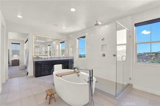 full bathroom with vanity, a shower stall, a freestanding tub, and tile patterned flooring