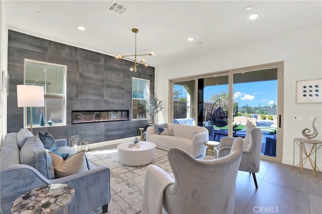 living room featuring a large fireplace, a chandelier, visible vents, and recessed lighting