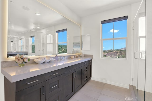 bathroom featuring tile patterned floors, baseboards, a shower stall, and vanity