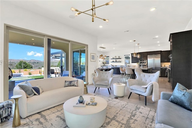 living area featuring recessed lighting, a mountain view, and an inviting chandelier