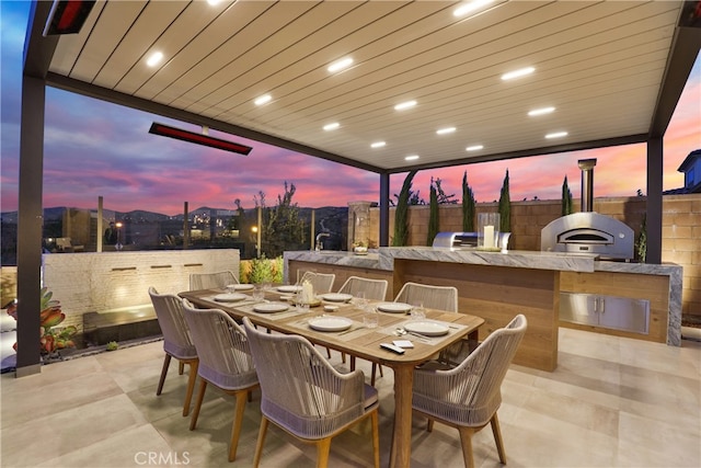 view of patio / terrace with fence, exterior kitchen, and outdoor dining space