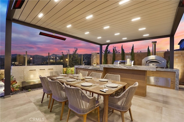 view of patio with area for grilling, outdoor dining area, and fence