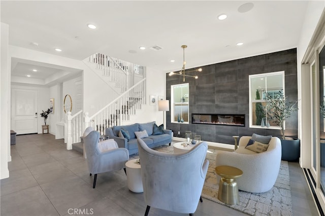 living room featuring a large fireplace, stairway, visible vents, and recessed lighting