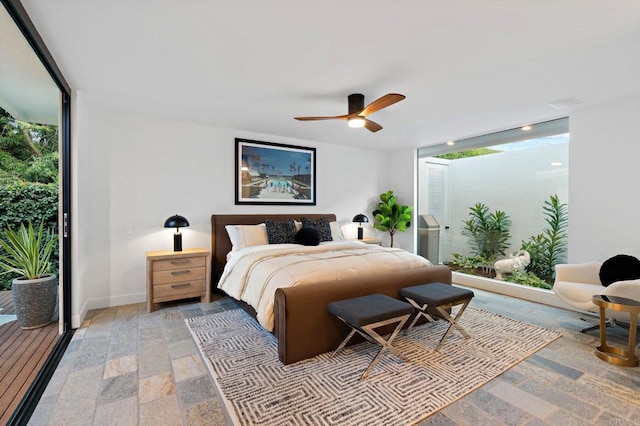 bedroom featuring baseboards, a wall of windows, and a ceiling fan