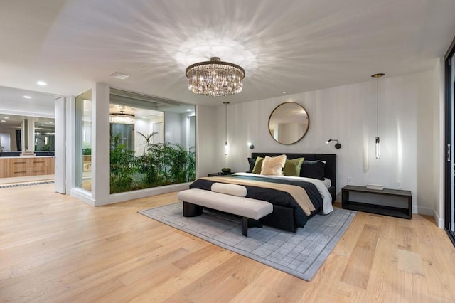 bedroom featuring light wood-style floors, recessed lighting, ensuite bathroom, and an inviting chandelier