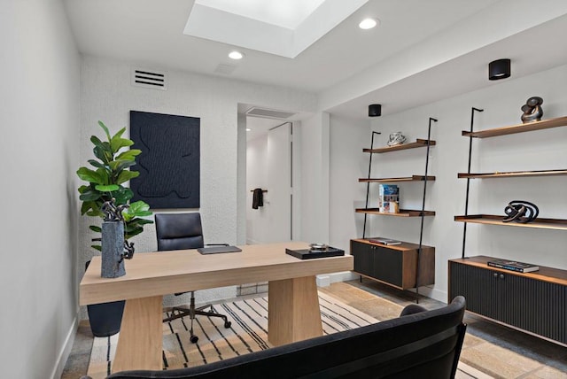 office space featuring baseboards, a skylight, visible vents, and recessed lighting