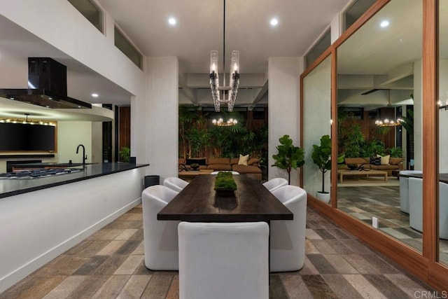 dining space with baseboards, a chandelier, and recessed lighting