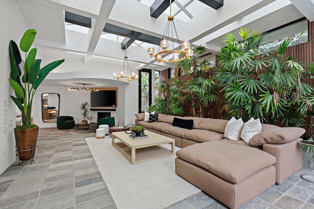 living area featuring a chandelier, beam ceiling, coffered ceiling, and a fireplace