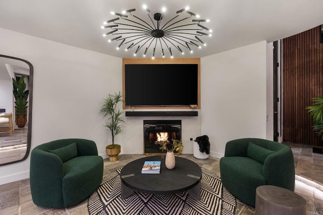 living room with track lighting, a glass covered fireplace, and baseboards