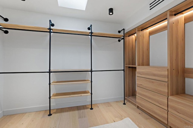 walk in closet featuring a skylight, visible vents, and wood finished floors