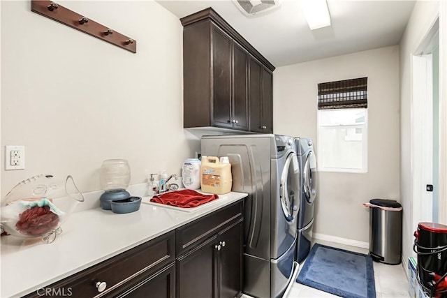 clothes washing area with cabinet space, baseboards, visible vents, and independent washer and dryer