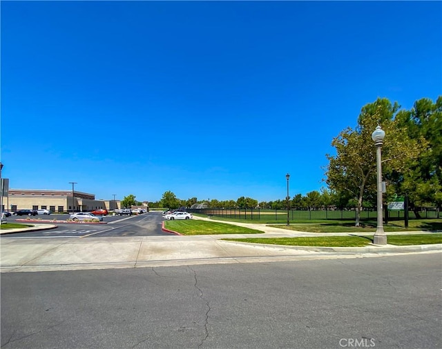 view of road with sidewalks, street lighting, and curbs