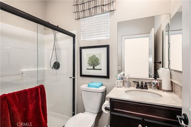 full bathroom featuring a stall shower, vanity, and toilet