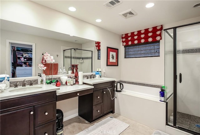 bathroom featuring a garden tub, a stall shower, vanity, and visible vents