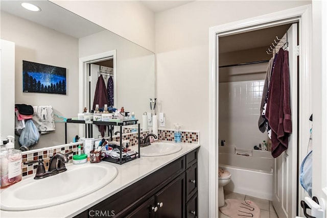 bathroom featuring double vanity, tasteful backsplash, tile patterned flooring, and a sink