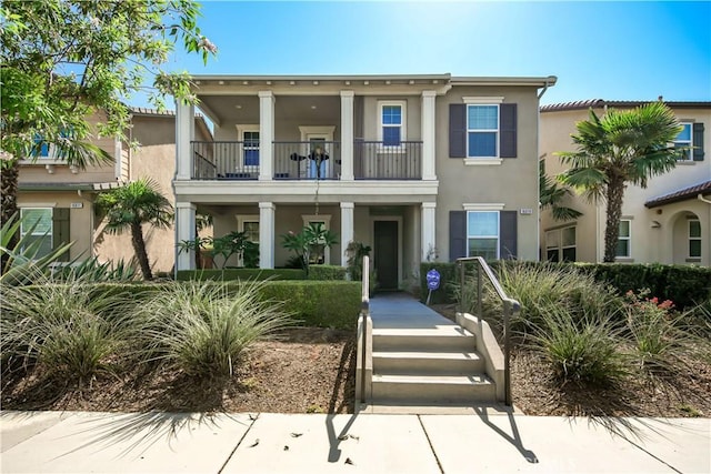 view of front of property with a balcony and stucco siding