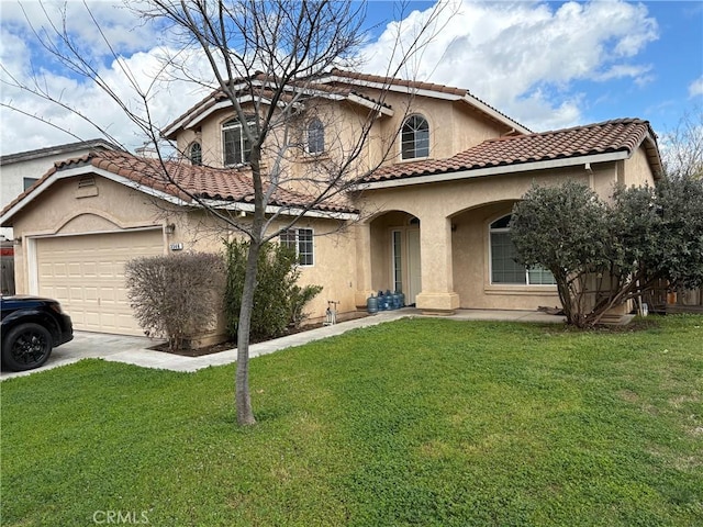 mediterranean / spanish home with driveway, a tiled roof, an attached garage, a front lawn, and stucco siding