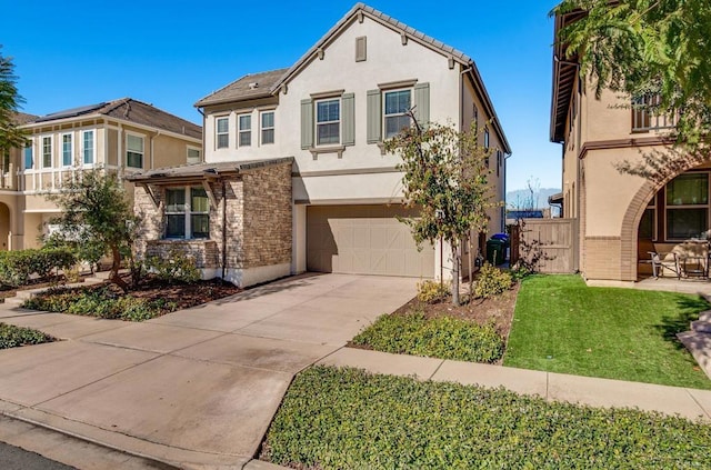 view of front of home featuring an attached garage, concrete driveway, stone siding, stucco siding, and a front yard