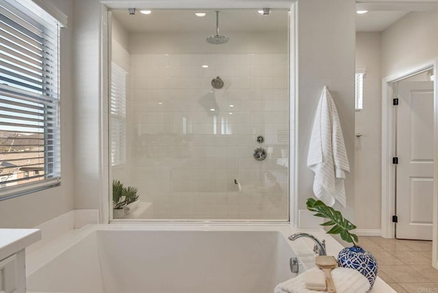 full bath with a healthy amount of sunlight, tile patterned flooring, a tile shower, and a bath