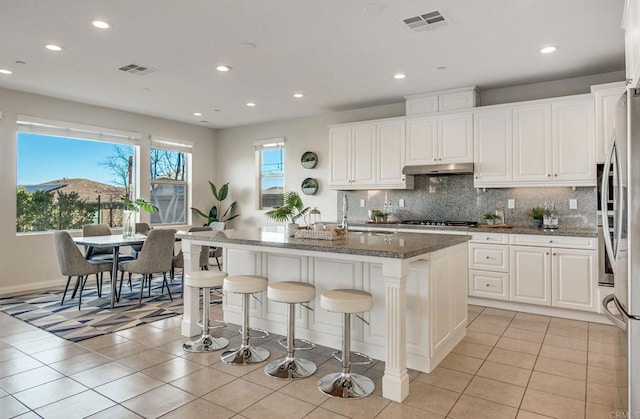 kitchen with stainless steel appliances, visible vents, a sink, and under cabinet range hood