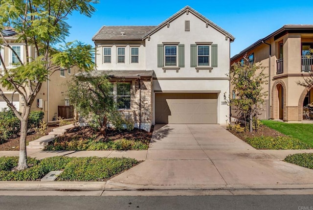 view of front of house featuring concrete driveway, an attached garage, and stucco siding