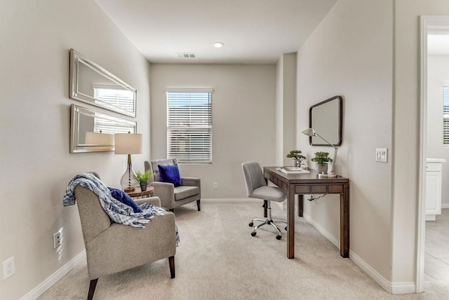 office space with light carpet, visible vents, and baseboards